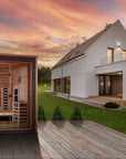 Visby sauna sited beside a house, showing the scale against the building