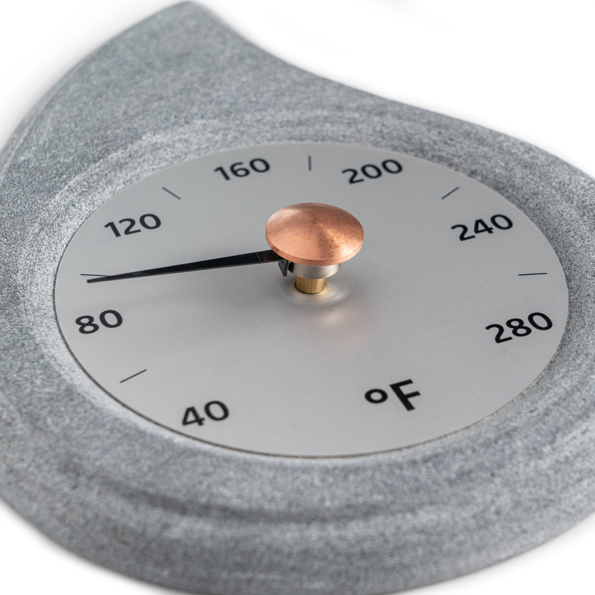 close up angle of stone teardrop shaped sauna thermometer with a brass knob on a white background