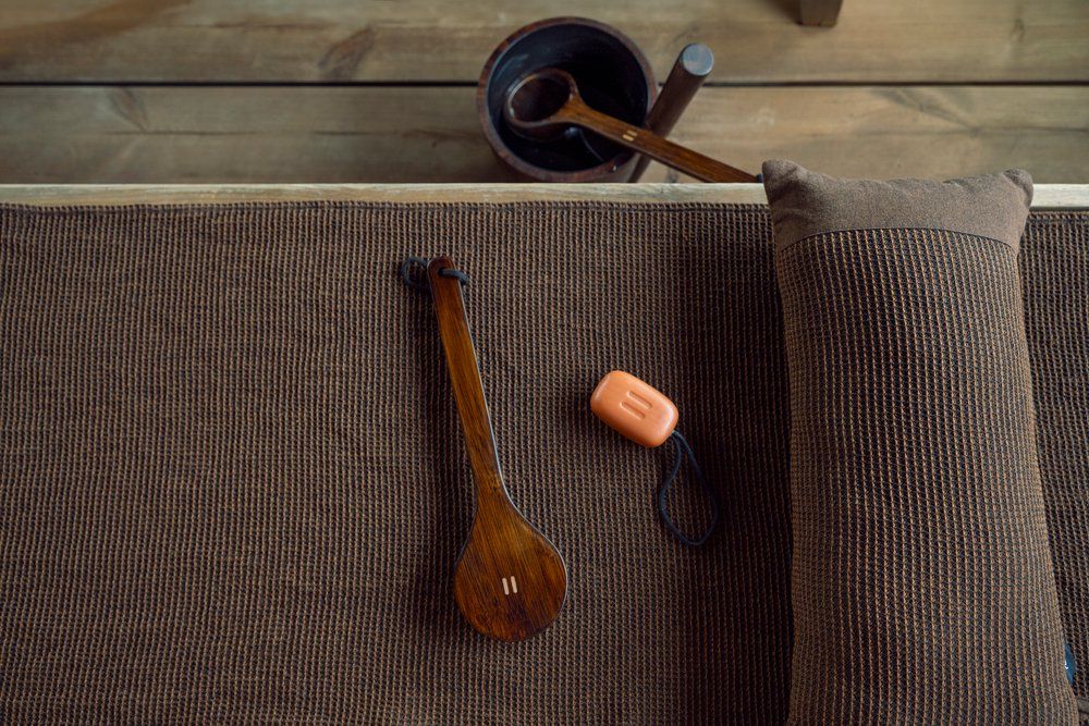 Wooden brush and other items on a textured surface with a wooden background
