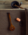 Wooden brush and other items on a textured surface with a wooden background