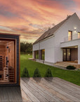 Nora sauna in a landscaped yard at dusk