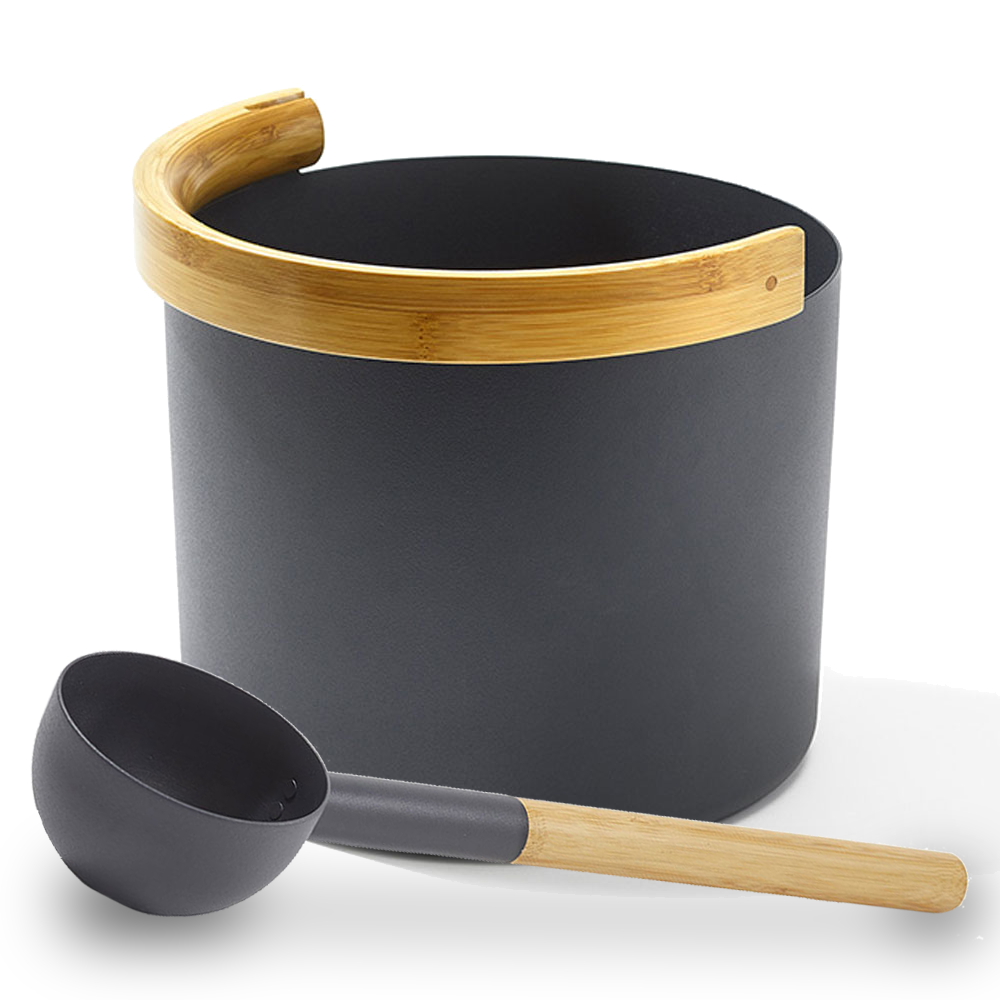 Black aluminum sauna bucket with curved bamboo handle and a matching ladle next to it against a white background