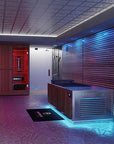 A modern indoor spa or wellness room featuring a large stainless steel cold plunge tub and wood sauna/steam unit, a glass shower enclosure, a red sauna compartment, patterned flooring, and ambient blue and purple lighting.