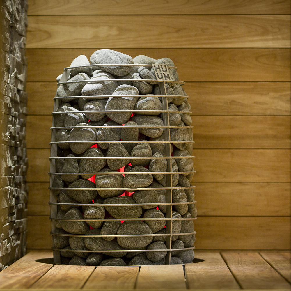 Stack of stones in a metal basket against a wooden wall