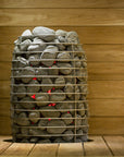 Stack of stones in a metal basket against a wooden wall