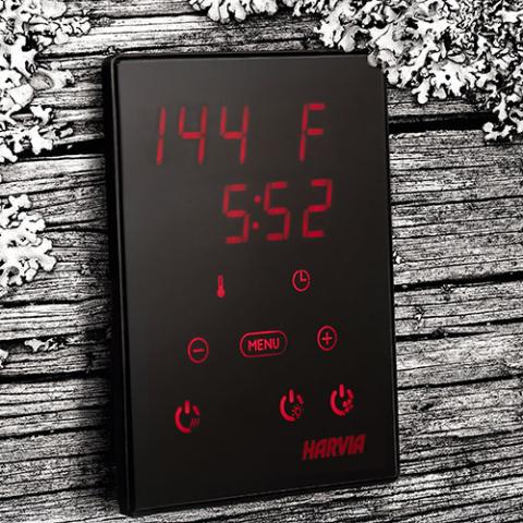 Harvia Xenio Control Panel mounted on wood wall with temperature, time, and icons for wi-fi, menu, timer, on and off