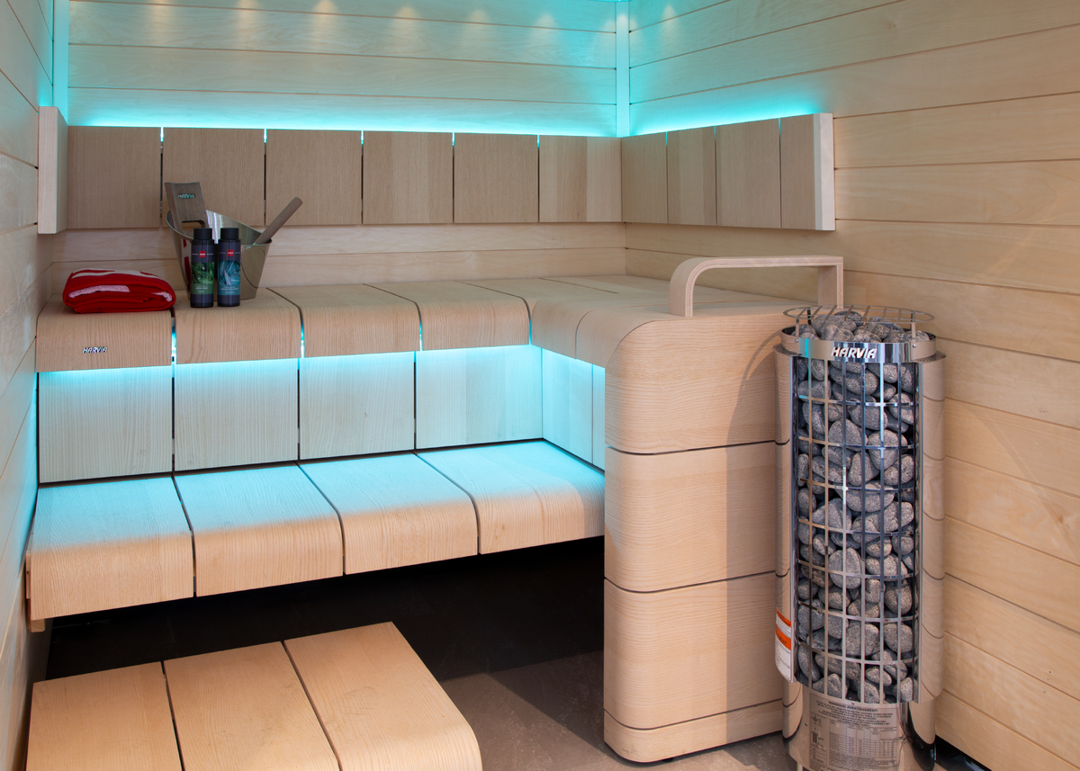 Harvia Cilindro Sauna Heater E series full view with stones underneath stainless steel grate sauna interior with light blue indirect LED lighting