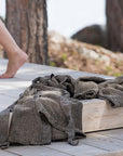 Brown texturedsauna robe on a wooden surface with a blurred natural background