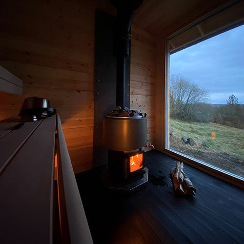 Narvi Luosto VS Sauna Stove broad view from interior of sauna with wood laying next to heater