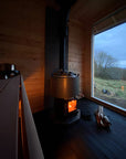 Narvi Luosto VS Sauna Stove broad view from interior of sauna with wood laying next to heater