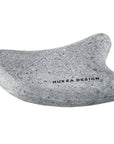 Gray guasha sauna stone with 'Hukka Design' branding on a white background