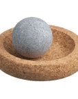 Cork bowl with a gray stone ball on a white background