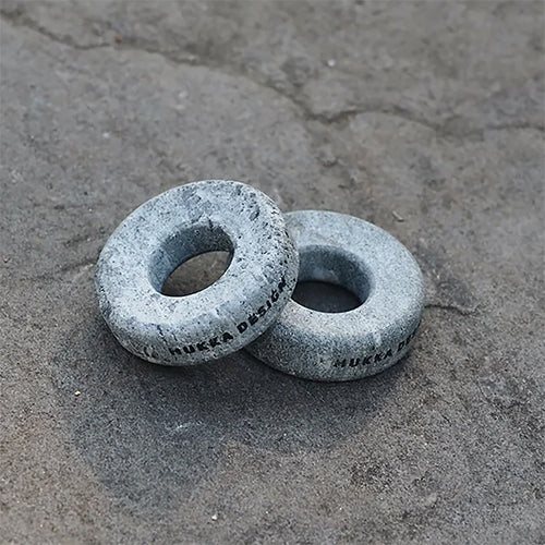 Two cold therapy eye stones on a concrete surface with 'Hukka Design' branding.