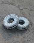 Two cold therapy eye stones on a concrete surface with 'Hukka Design' branding.