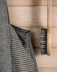 Gray textured bag with a patterned strap against a wooden background