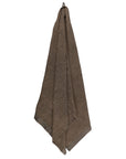 Brown textured towel hanging on a white background
